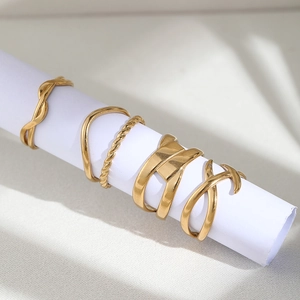 Detailed view of 5-piece gold geometric ring set with spiral and wave textures
