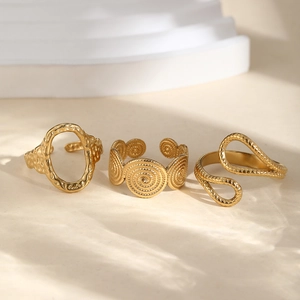 Three-piece set of golden stainless steel rings with textured and spiral geometric designs