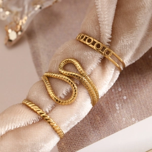 Detailed close-up of a three-piece gold vintage hollow ring set on champagne velvet