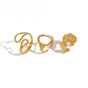 Detailed view of three gold stainless steel rings with wave, hammered and spiral textures