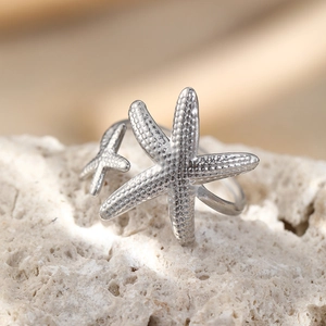 Macro view of silver starfish toe ring featuring textured details on white stone
