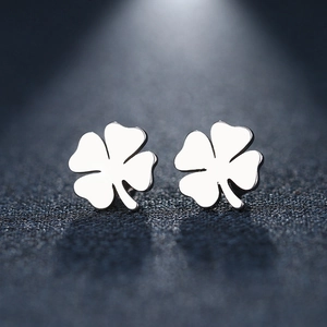 Polished silver stainless steel four-leaf clover stud earrings on a dark textured background