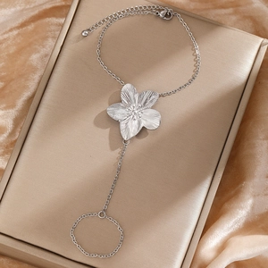 Silver sunflower finger bracelet in stainless steel displayed on gold velvet jewelry box