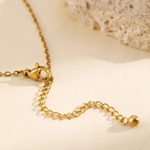 Close-up of gold stainless steel extension chain with lobster clasp and round bead