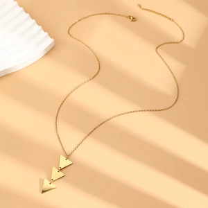 Macro detail of gold triple triangle pendant necklace with fine chain and lobster clasp