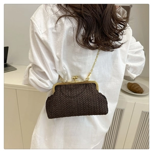 Détail d'un sac bandoulière tressé marron foncé avec fermoir doré et bandoulière