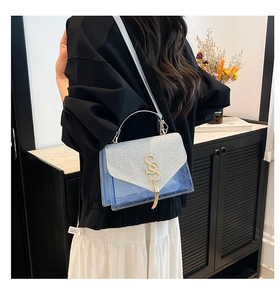 Detail of transparent blue PVC bag with silver glitter flap and gold S-shaped logo