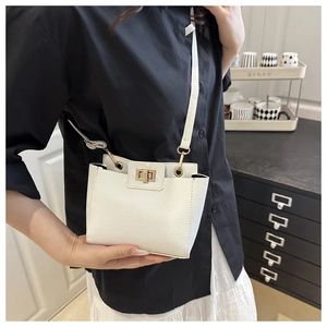 Détail du mini sac blanc en cuir grainé avec fermoir rotatif en métal doré chic