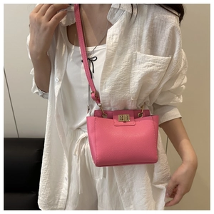 Détail de la texture cuir litchi rose et fermoir doré du sac à bandoulière pour femme