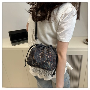 Détail d'un sac seau floral vintage avec bandoulière en cuir réglable et cordon