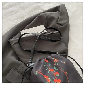 Détail du sac seau noir à cordon avec imprimés floraux traditionnels chinois sur tissu