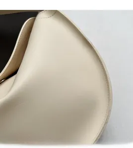 Close-up of beige faux leather tote bag showing fine lychee grain texture and neat stitching
