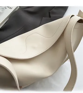 Detail of wave-shaped manual stitching and smooth edge on creamy white tote bag
