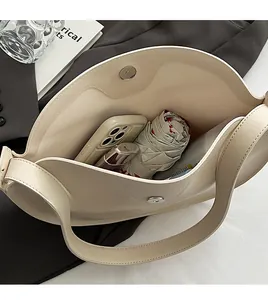 Internal view of spacious beige half-moon tote bag showing storage for phone and umbrella