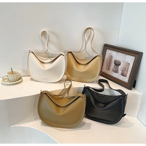 Detail of minimalist dumpling tote bags in four neutral colors on elegant display stands