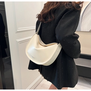 Detail of a minimalist cream crescent shoulder bag with elegant leather texture