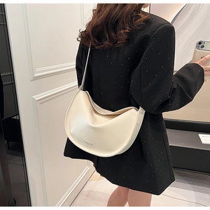 Minimalist white leather crescent shoulder bag shown on model for size perspective
