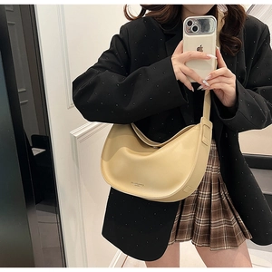 Detail of light beige crescent shoulder bag made of matte leather with logo print