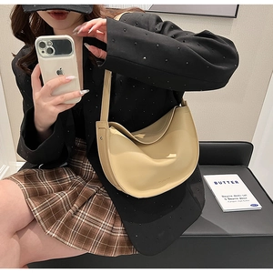 Detail of minimalist beige half-moon tote bag with smooth matte leather texture for women