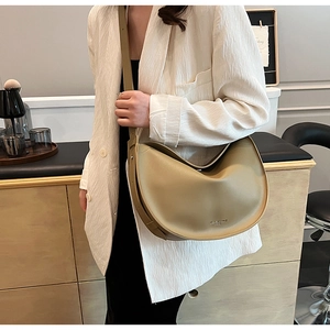 Detail view of khaki crescent tote bag showing natural drape and matte leather texture