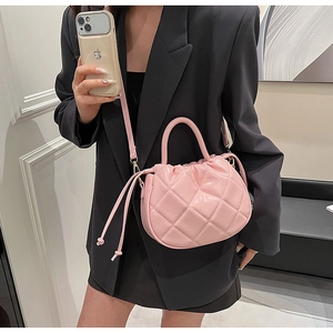 Detailed view of pink quilted leather bucket bag with drawstring and silver hardware
