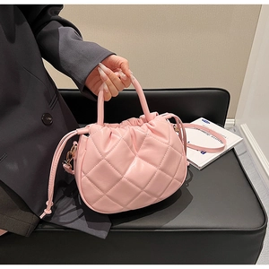 Detailed view of pink quilted cloud bucket bag with drawstring and shoulder strap