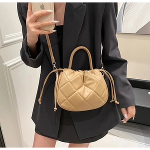 Close-up of khaki quilted cloud bucket bag with drawstring and adjustable strap