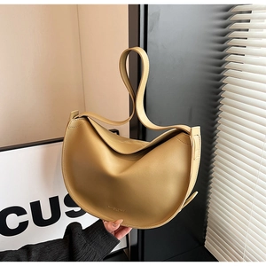 Close-up of beige leather hobo bag featuring gold logo and smooth pebble texture