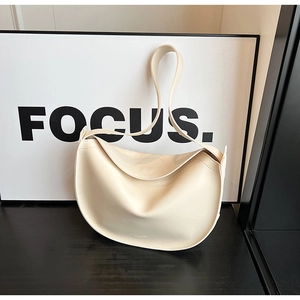 Detail view of cream crescent tote bag featuring fine stitching and subtle embossed texture