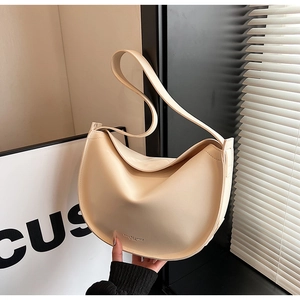 Detail of a creamy half-moon hobo bag with matte leather finish and embossed logo