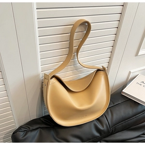 Detail of light khaki crescent tote bag with smooth matte finish and adjustable strap
