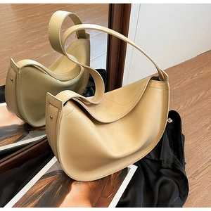 Close-up of beige crescent shoulder bag made of smooth leather with stitch details