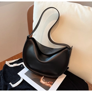Detail of minimalist black matte leather hobo bag with smooth curved design on soft pillows
