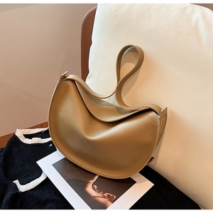 Close-up of khaki leather hobo bag with wide strap on white sofa background