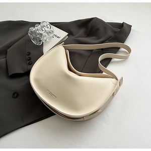 Detailed close-up of a cream crescent hobo bag featuring a smooth matte leather finish