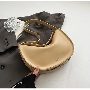 Detail of khaki leather crescent tote bag on grey blazer with luxury aesthetic