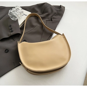 Detail view of cream crescent hobo bag with wide strap and minimalist matte finish