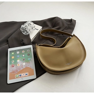 Detail of khaki crescent tote bag on blazer with iPad and urban lifestyle items
