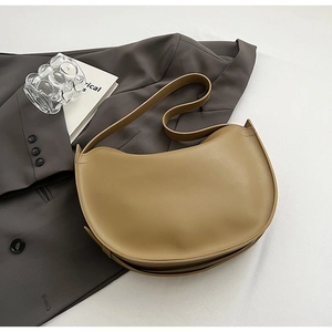 Detailed side view of khaki crescent tote bag with smooth matte leather and minimal stitching