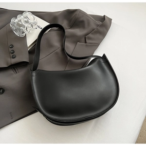 Top view of black leather hobo bag on grey blazer for a minimalist fashion lifestyle look