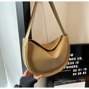 Detail view of khaki crescent shoulder bag with matte leather finish and wide strap