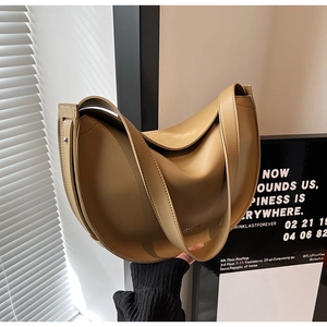 Detail view of a beige crescent tote bag featuring a wide strap and smooth PU leather