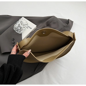 Interior detail of khaki tote bag showing magnetic clasp and spacious storage compartment