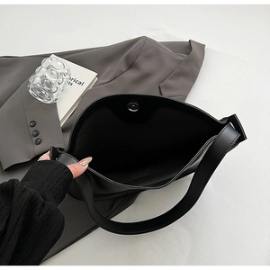 Interior detail of black leather tote bag featuring a secure magnetic snap closure
