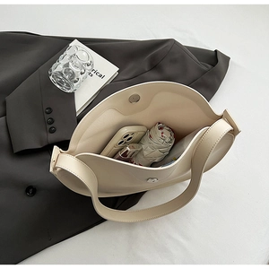 Detail of off-white tote bag showing magnetic closure and spacious interior storage