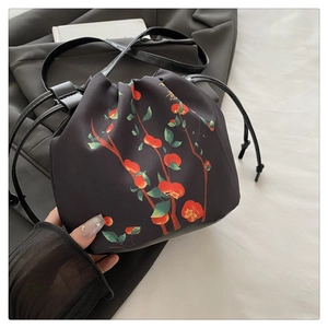 Détail du sac seau à cordon noir avec motif de persimmon rouge et caractère doré