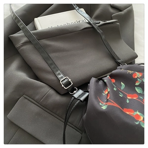 Détail d'un sac bandoulière noir mat avec pochette intérieure à cordon fleurie