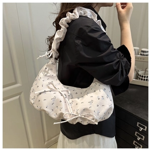 Detail of floral crescent bag with bow decoration and pleated shoulder strap