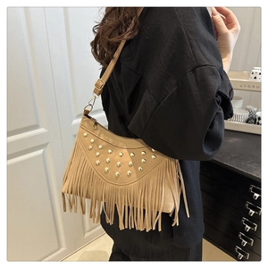 Detail of khaki suede shoulder bag featuring long tassels and gold rivet studs