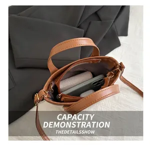 Interior view showing the capacity of this brown leather bucket bag for phone and wallet